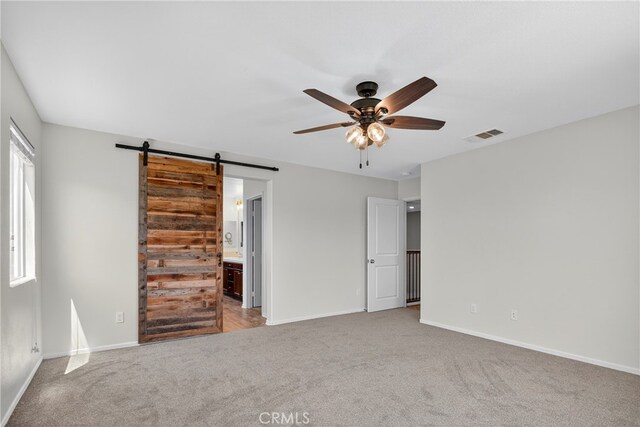 102 Mesa Ct, Calimesa, CA 92320 - unfurnished bedroom with carpet floors, a barn door, and ensuite bath