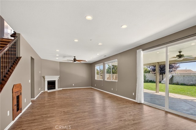102 Mesa Ct, Calimesa, CA 92320 - unfurnished living room with a fireplace with raised hearth, ceiling fan, wood finished floors, recessed lighting, and stairs