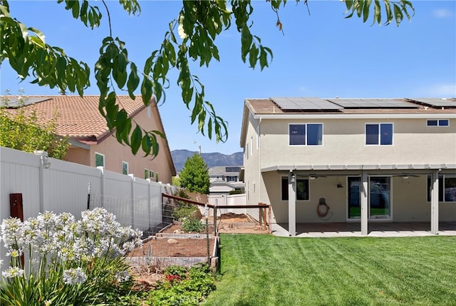 102 Mesa Ct, Calimesa, CA 92320 - back of property featuring a garden, roof mounted solar panels, a fenced backyard, a patio, and stucco siding