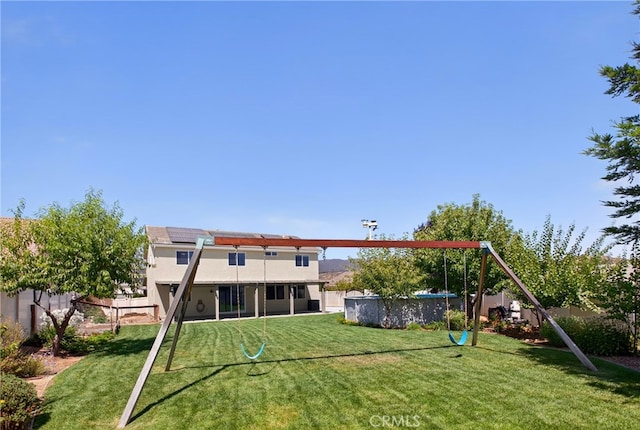 102 Mesa Ct, Calimesa, CA 92320 - rear view of property featuring roof mounted solar panels, an outdoor pool, a fenced backyard, and stucco siding