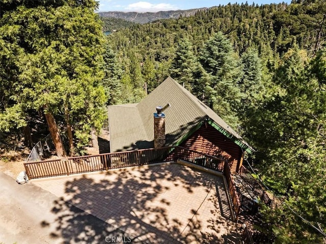 25148 Scenic View Dr, Crestline, CA 92325 - view of front of home featuring a wooded view, a chimney, and a deck