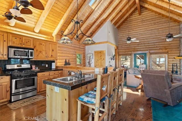 25148 Scenic View Dr, Crestline, CA 92325 - kitchen featuring stainless steel appliances, high vaulted ceiling, rustic walls, ceiling fan, and open floor plan