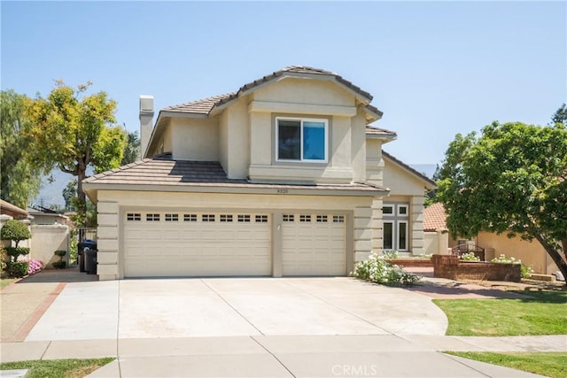 9320 Isaac Lord Dr, Rancho Cucamonga, CA 91701 - view of front of home with a garage, concrete driveway, a chimney, stucco siding, and a tiled roof