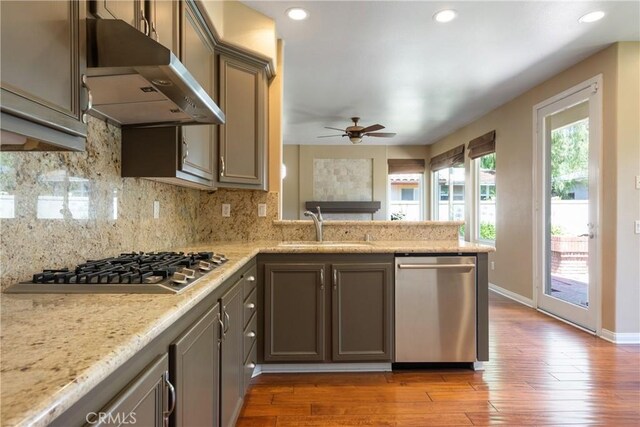 9320 Isaac Lord Dr, Rancho Cucamonga, CA 91701 - kitchen featuring appliances with stainless steel finishes, under cabinet range hood, ceiling fan, wood finished floors, and a peninsula