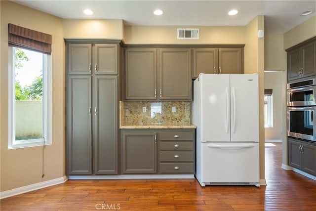 9320 Isaac Lord Dr, Rancho Cucamonga, CA 91701 - kitchen with freestanding refrigerator, double oven, gray cabinetry, wood finished floors, and decorative backsplash