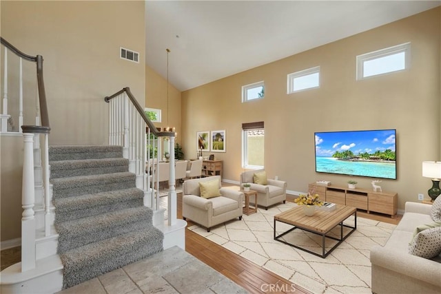 9320 Isaac Lord Dr, Rancho Cucamonga, CA 91701 - living area featuring a high ceiling, stairway, plenty of natural light, and wood finished floors
