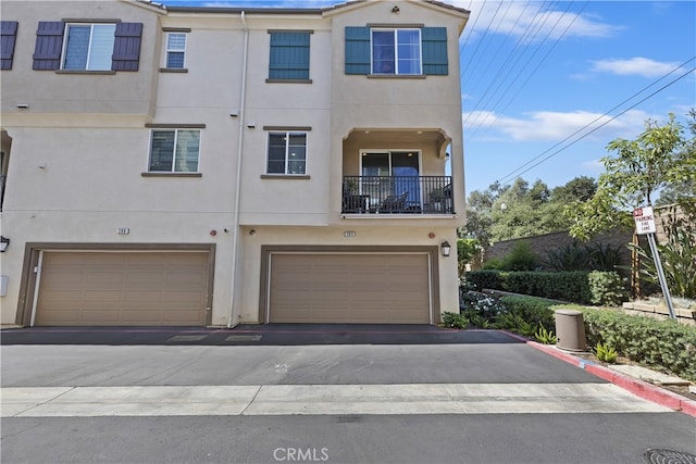 384 Ruby Red Ln, Upland, CA 91786 - view of property featuring stucco siding, an attached garage, and asphalt driveway