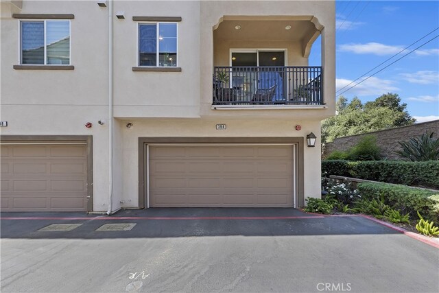 384 Ruby Red Ln, Upland, CA 91786 - view of front facade featuring an attached garage, stucco siding, and a balcony