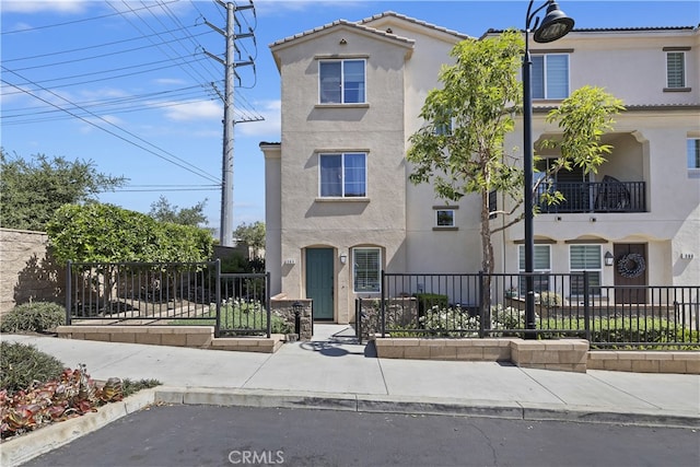 384 Ruby Red Ln, Upland, CA 91786 - view of front facade featuring stucco siding and a fenced front yard
