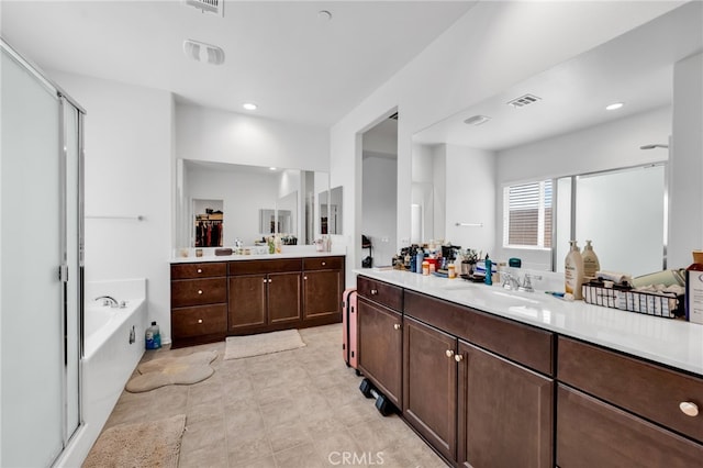 16252 Gibson St, Victorville, CA 92394 - full bathroom with a stall shower, two vanities, a bath, recessed lighting, and tile patterned floors