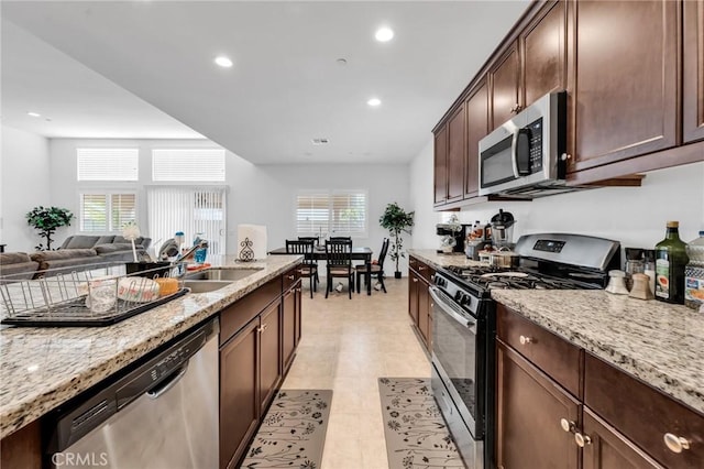 16252 Gibson St, Victorville, CA 92394 - kitchen featuring appliances with stainless steel finishes, light stone countertops, recessed lighting, dark brown cabinetry, and open floor plan