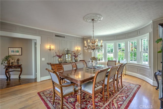1205 W Highland, Redlands, CA 92373 - dining area with a decorative wall, crown molding, a chandelier, and light wood-style floors