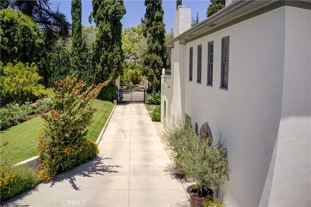 1205 W Highland, Redlands, CA 92373 - view of side of property with stucco siding, a chimney, and a lawn