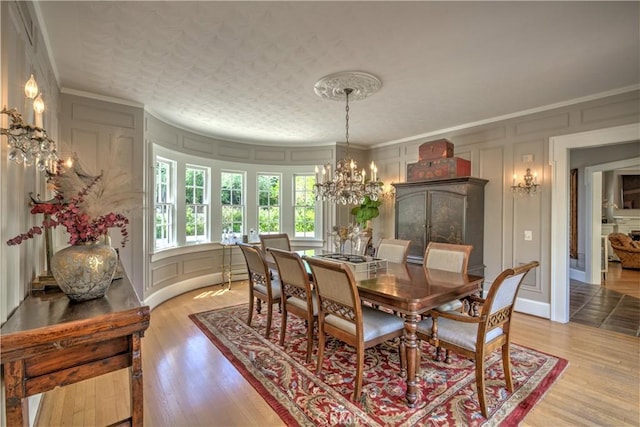 1205 W Highland, Redlands, CA 92373 - dining room with a decorative wall, a chandelier, ornamental molding, and light wood finished floors