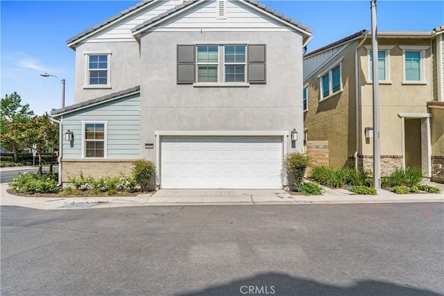 1633 Topeka Pl, Upland, CA 91784 - view of front of house featuring a garage, stucco siding, a tile roof, and brick siding