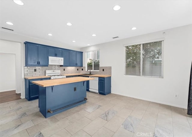 13837 Emerald Ln, Gardena, CA 90247 - kitchen featuring butcher block countertops, blue cabinets, white appliances, tasteful backsplash, and recessed lighting