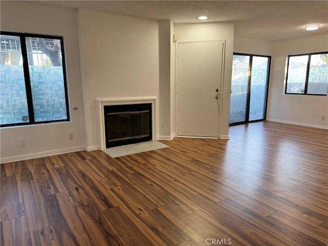 102 Park Shadow Ct, Baldwin Park, CA 91706 - unfurnished living room with a textured ceiling, wood finished floors, a textured wall, and a fireplace with flush hearth