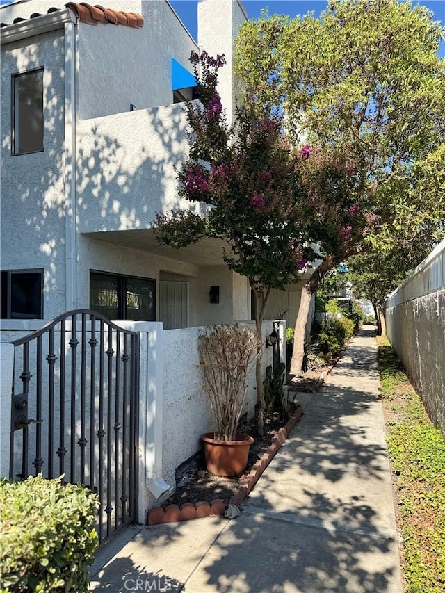 102 Park Shadow Ct, Baldwin Park, CA 91706 - view of side of property featuring stucco siding, a gate, and a tile roof