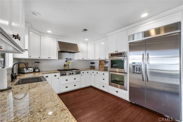 2622 S Pacific Ave, Santa Ana, CA 92704 - kitchen featuring stainless steel appliances, wall chimney range hood, dark wood finished floors, white cabinets, and recessed lighting