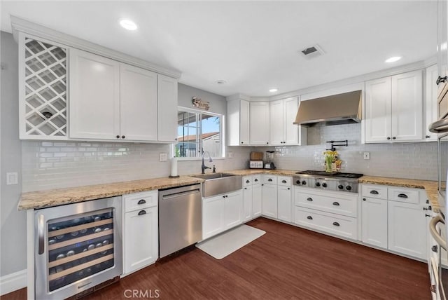 2622 S Pacific Ave, Santa Ana, CA 92704 - kitchen featuring beverage cooler, stainless steel appliances, wall chimney range hood, white cabinetry, and decorative backsplash