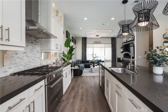 35 Ebb Tide Cir, Newport Beach, CA 92663 - kitchen with wall chimney range hood, stainless steel appliances, dark countertops, dark wood-type flooring, and recessed lighting