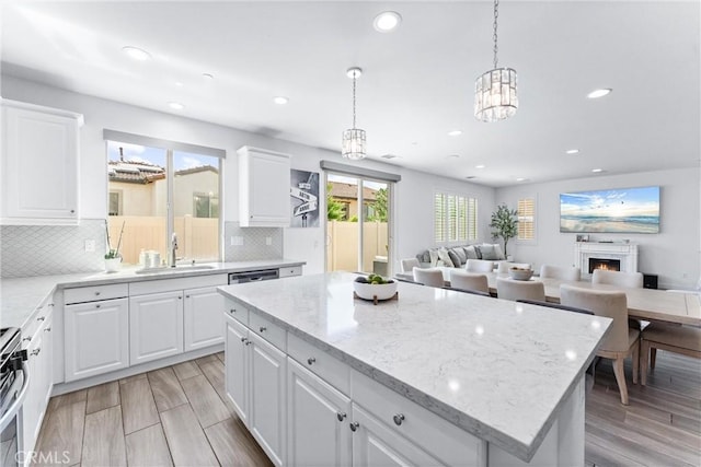 2825 Villa Catalonia Ct, Corona, CA 92881 - kitchen with recessed lighting, backsplash, light stone countertops, a center island, and white cabinetry