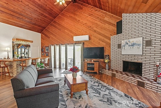 3110 N Greenbrier Rd, Long Beach, CA 90808 - living room featuring high vaulted ceiling, wooden ceiling, a wall mounted air conditioner, a brick fireplace, and wood walls