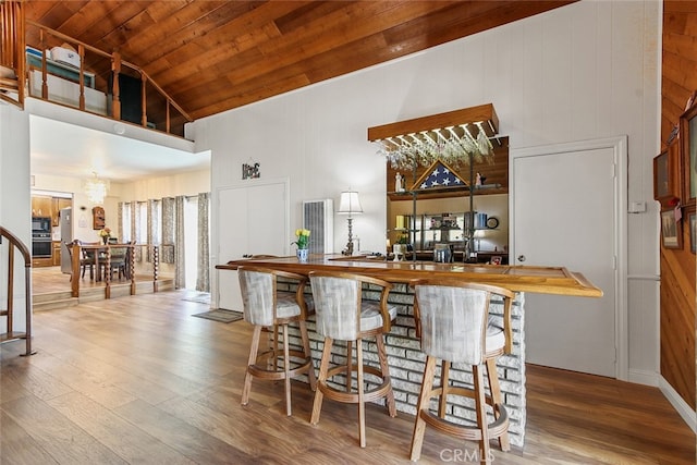 3110 N Greenbrier Rd, Long Beach, CA 90808 - indoor bar featuring high vaulted ceiling, wood finished floors, wood ceiling, black microwave, and wooden walls