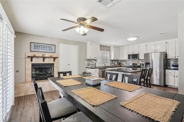 1519 Bluejay Way, Hemet, CA 92545 - dining area with a ceiling fan, dark wood finished floors, and a fireplace