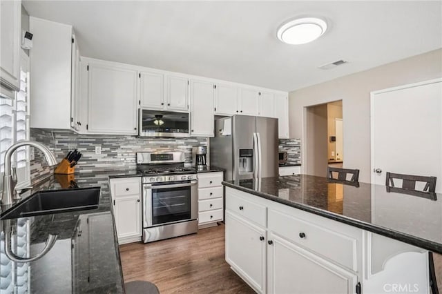 1519 Bluejay Way, Hemet, CA 92545 - kitchen with stainless steel appliances, tasteful backsplash, white cabinets, and dark wood-type flooring