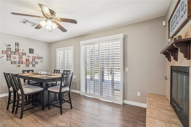 1519 Bluejay Way, Hemet, CA 92545 - dining room with wood finished floors, a ceiling fan, and a glass covered fireplace