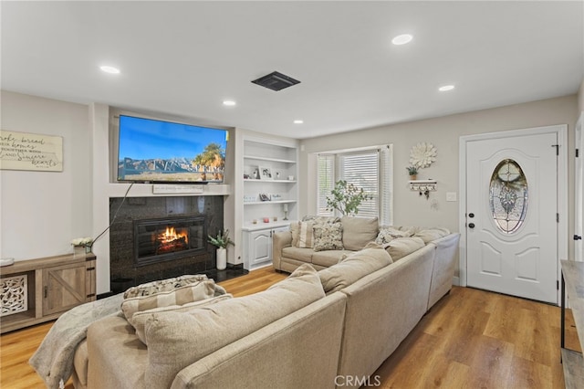 1443 E Devonshire Ave, Hemet, CA 92544 - living area with a glass covered fireplace, wood finished floors, recessed lighting, and built in shelves