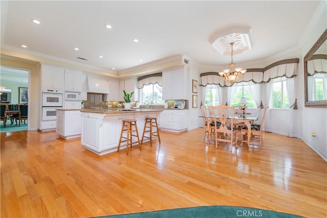 2809 Oak Knoll Dr, Diamond Bar, CA 91765 - kitchen featuring white appliances, a breakfast bar, a kitchen island, white cabinetry, and ornamental molding