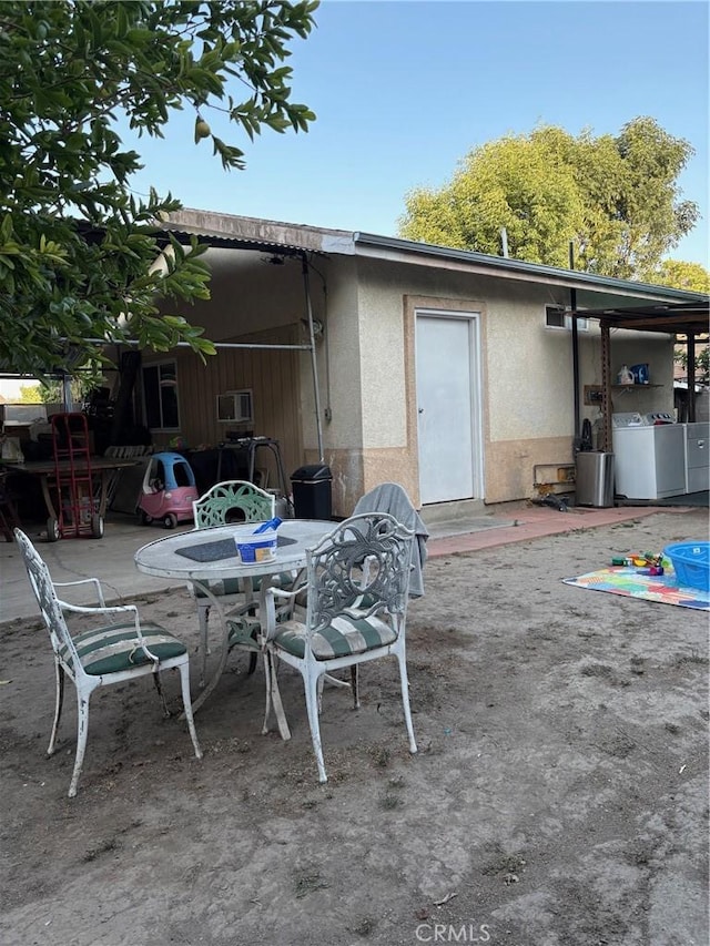 1140 W Cubbon St, Santa Ana, CA 92703 - rear view of house featuring washer / dryer, a patio area, stucco siding, and outdoor dining space