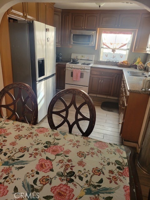 1140 W Cubbon St, Santa Ana, CA 92703 - kitchen with white gas stove, stainless steel fridge with ice dispenser, and arched walkways