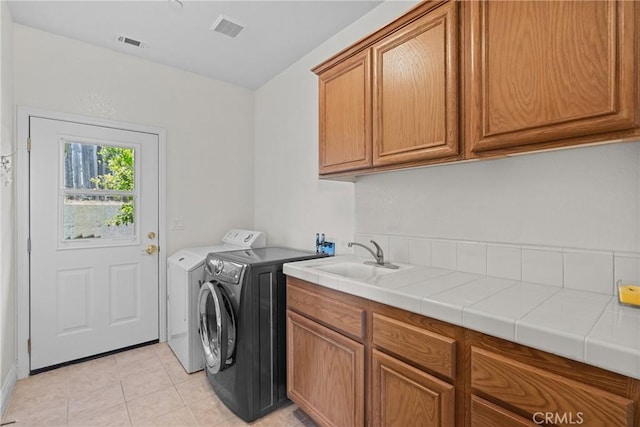 12703 Paso Verde Ct, Atascadero, CA 93422 - washroom featuring cabinet space, washing machine and clothes dryer, and light tile patterned flooring