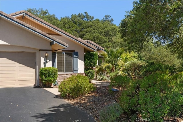 12703 Paso Verde Ct, Atascadero, CA 93422 - property entrance featuring stucco siding, an attached garage, asphalt driveway, and stone siding