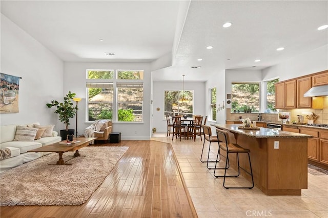 12703 Paso Verde Ct, Atascadero, CA 93422 - kitchen featuring open floor plan, plenty of natural light, a kitchen bar, recessed lighting, and a center island