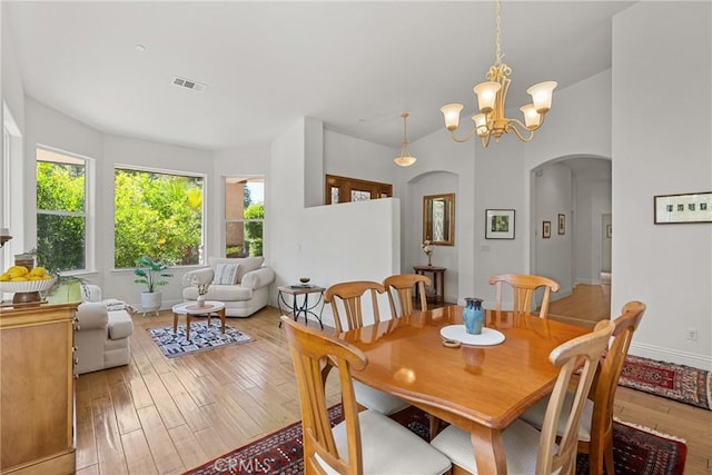 12703 Paso Verde Ct, Atascadero, CA 93422 - dining space with arched walkways, light wood-style flooring, and a chandelier
