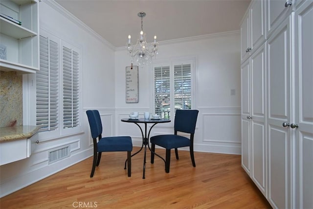 4161 Dixie Canyon Ave, Sherman Oaks, CA 91423 - dining area featuring a chandelier, light wood-style flooring, a decorative wall, crown molding, and wainscoting