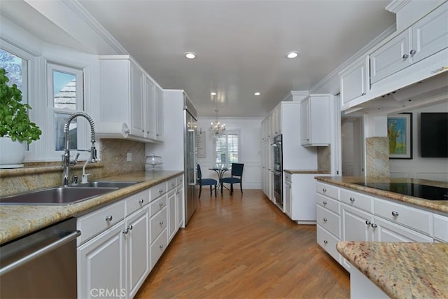 4161 Dixie Canyon Ave, Sherman Oaks, CA 91423 - kitchen with stainless steel appliances, a chandelier, white cabinetry, light wood-style floors, and recessed lighting