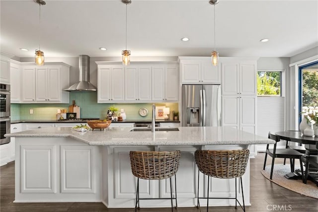 5 Catalina Point Rd, Chico, CA 95928 - kitchen with wall chimney range hood, stainless steel appliances, an island with sink, white cabinetry, and recessed lighting