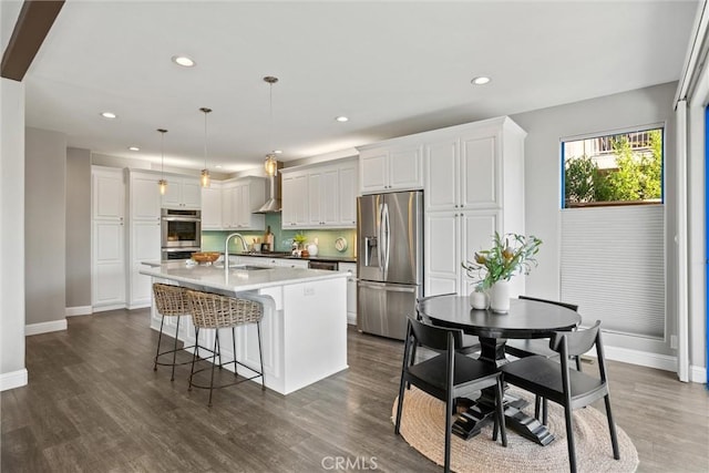 5 Catalina Point Rd, Chico, CA 95928 - kitchen with stainless steel appliances, recessed lighting, an island with sink, wall chimney exhaust hood, and white cabinetry