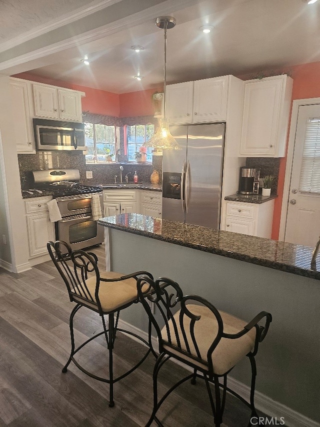 8686 San Juan Ave, South Gate, CA 90280 - kitchen featuring appliances with stainless steel finishes, decorative backsplash, white cabinetry, ornamental molding, and recessed lighting