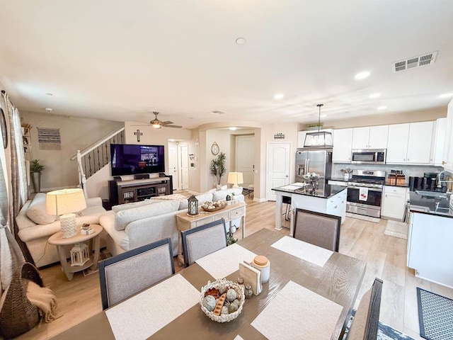 1410 Franceschi Dr, Chula Vista, CA 91913 - dining room featuring stairway, a ceiling fan, arched walkways, light wood-style flooring, and recessed lighting