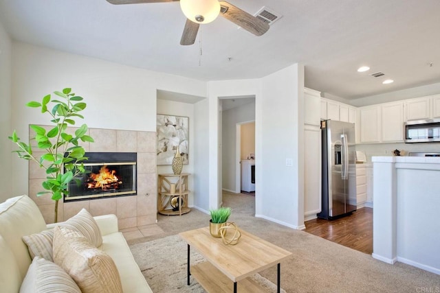 33657 Emerson Way Unit C, Temecula, CA 92592 - living room featuring carpet flooring, washer / clothes dryer, a tile fireplace, a ceiling fan, and recessed lighting