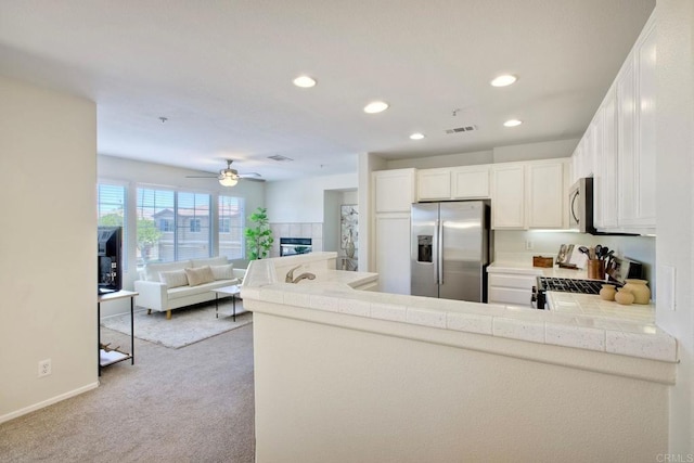 33657 Emerson Way Unit C, Temecula, CA 92592 - kitchen with stainless steel appliances, recessed lighting, light carpet, tile countertops, and a peninsula