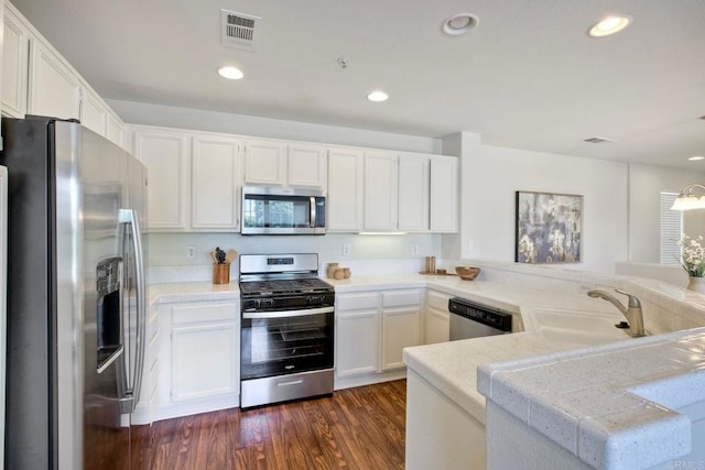 33657 Emerson Way Unit C, Temecula, CA 92592 - kitchen featuring appliances with stainless steel finishes, white cabinets, recessed lighting, a peninsula, and dark wood-style flooring