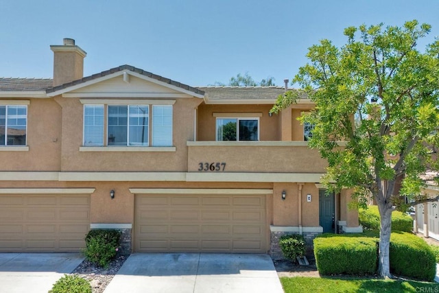 33657 Emerson Way Unit C, Temecula, CA 92592 - multi unit property with an attached garage, driveway, a chimney, and stucco siding