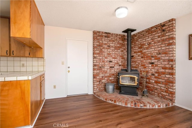 46404 Kings Canyon Rd, Lancaster, CA 93536 - unfurnished living room featuring dark wood finished floors, a wood stove, and a textured ceiling
